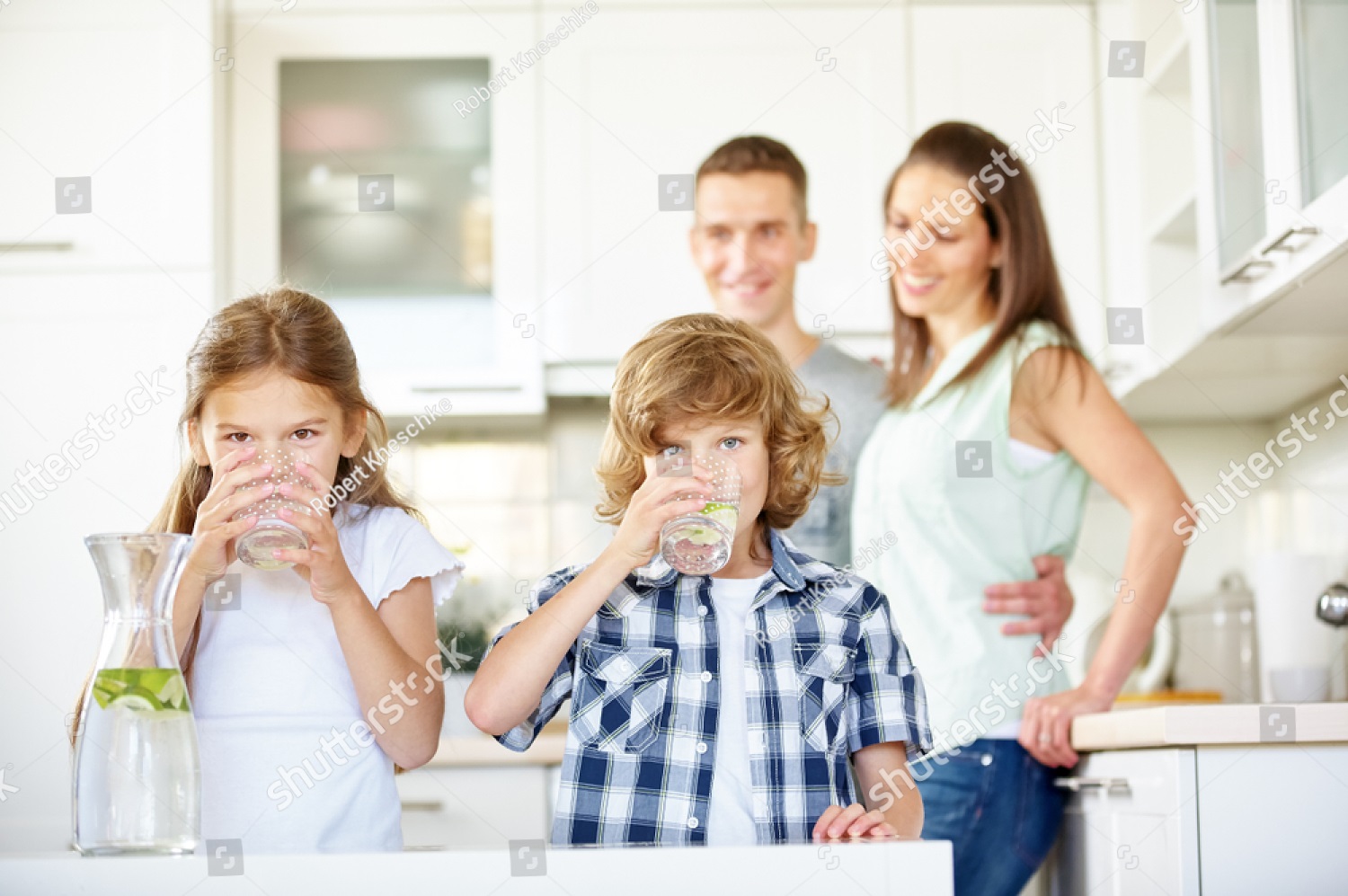stock-photo-children-drink-fresh-water-with-limes-in-the-kitchen-in-front-of-their-parents-1628608558